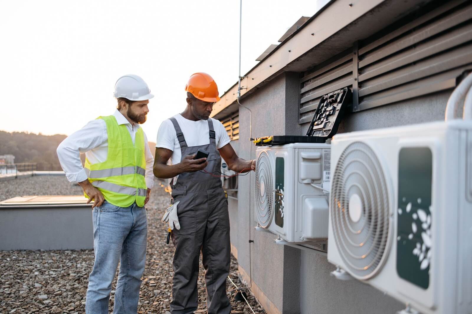 HVAC technicians are inspecting and servicing an air conditioning unit outdoors