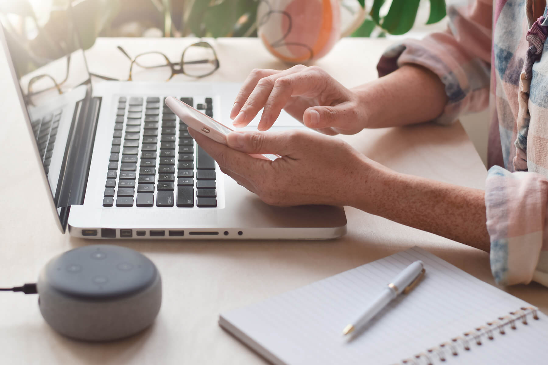 Virtual assistant sitting at a desk with laptop computer and office tools