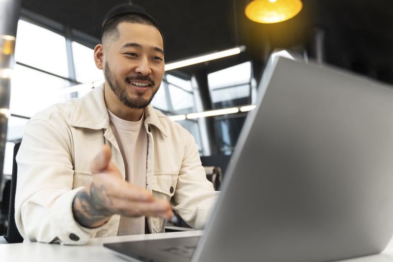 Casual business man looking at a computer and smiling